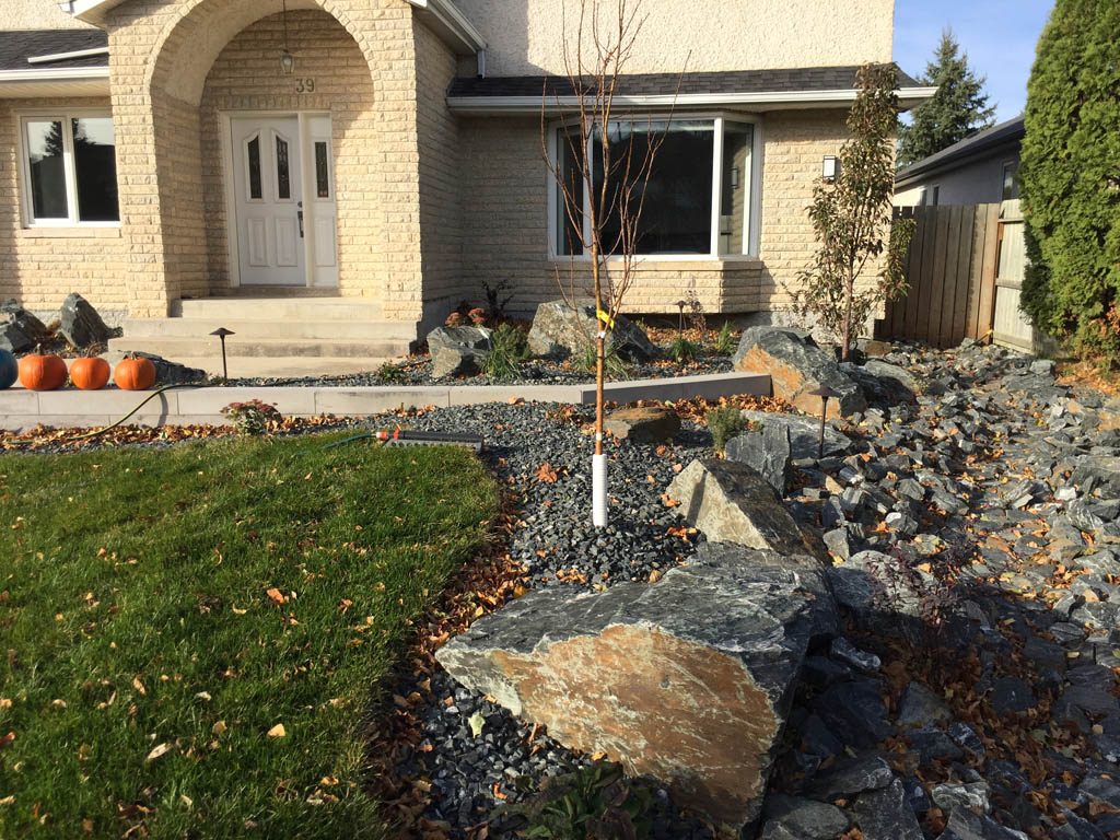 Front yard renovation with Architextures retaining wall, black granite, plants, sod