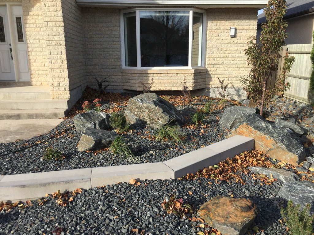 Front yard renovation with Architextures retaining wall, black granite, plants, sod