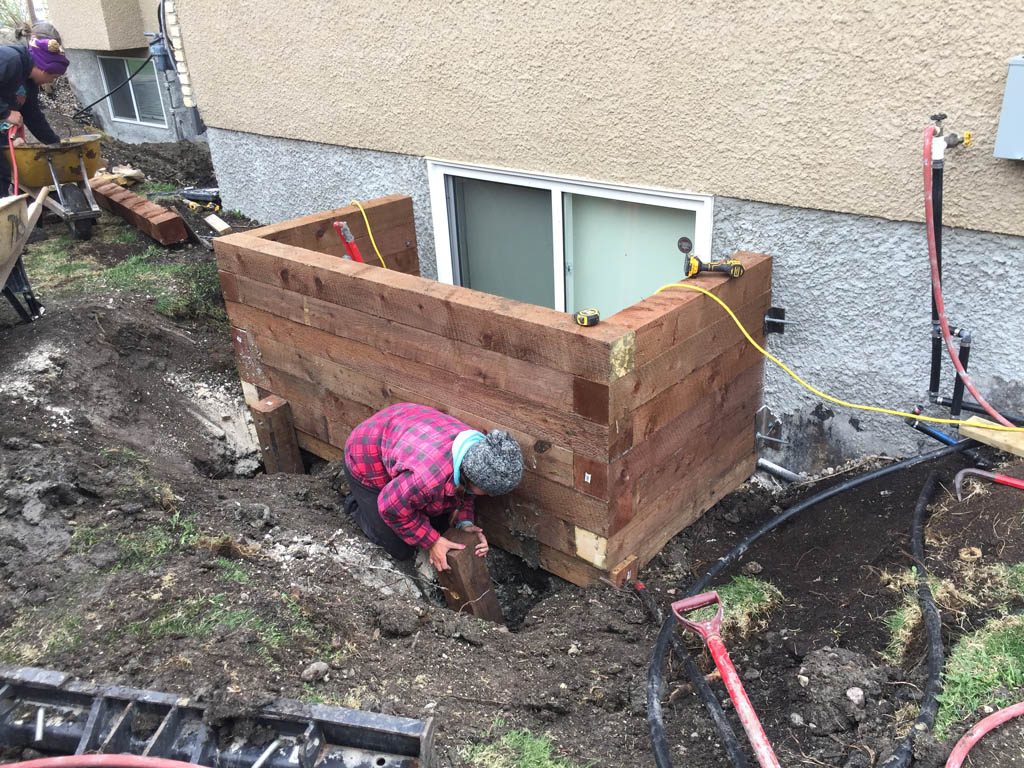 Swim spa pad, large window wells, re-grading, flagstone pathway, and decorative stone