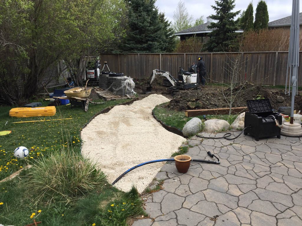 Swim spa pad, large window wells, re-grading, flagstone pathway, and decorative stone