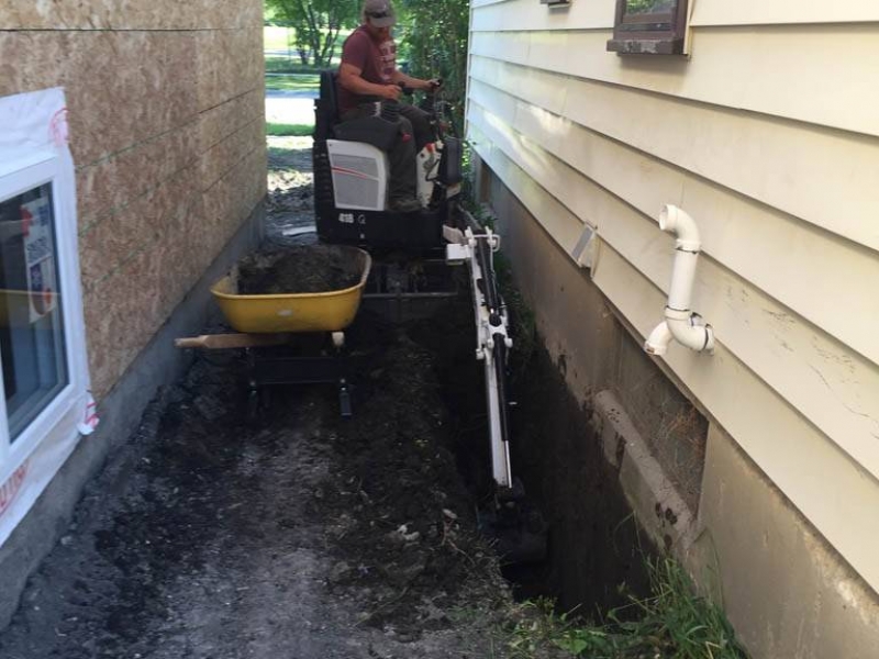 Mini excavator digging for foundation repair