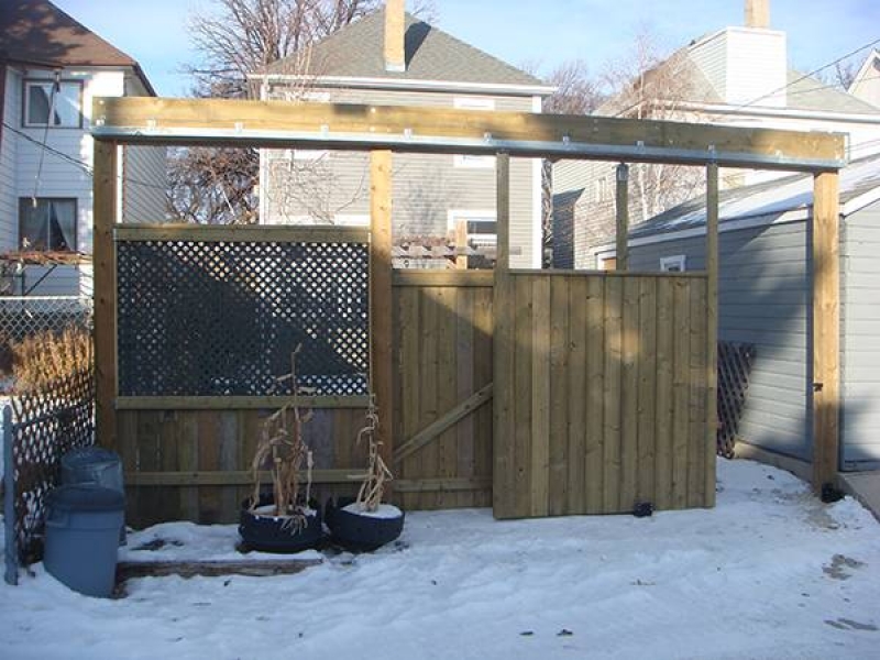 Treated green fence with double sliding door for vehicle access